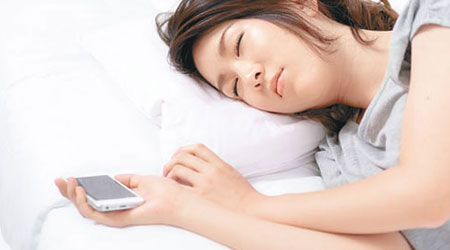 不少人睡覺時也要握住手機。（互聯網圖片）