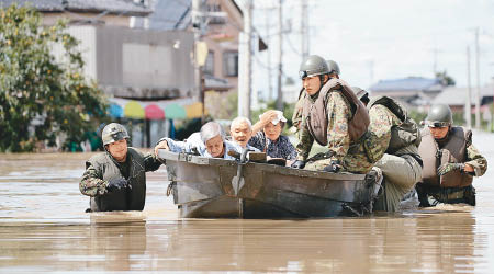 救援人員乘橡皮艇把災民送往安全地方。