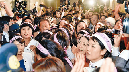 在野黨女議員戴上粉紅頭箍，在通道築成人牆。