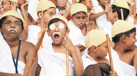 一眾小朋友戴上眼鏡、假鬍鬚，穿上傳統白色腰布並手持竹竿，與甘地形象極為酷似。