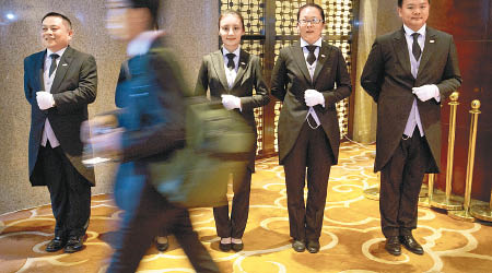 管家學院畢業生在北京一會議入口處端正站立，靜候服務。
