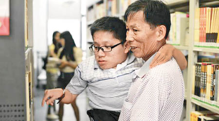 黃父抱起兒子黃耀輝到圖書館。（互聯網圖片）