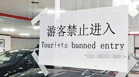 首爾一家汽車銷售店入口貼出簡體字告示，禁止遊客進入。