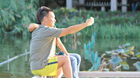 廣州有市民穿短袖衫在公園內自拍。（互聯網圖片）