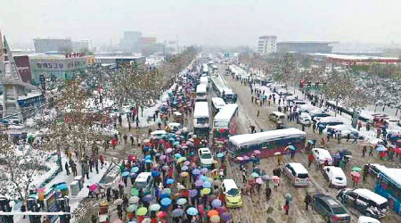 鄭州暴雪導致交通擠塞，巴士站現人龍。（互聯網圖片）