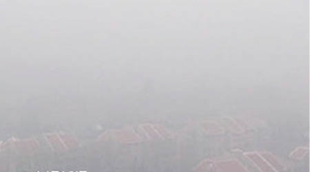 北京昨再遭霧霾侵襲，建築物一片灰濛。