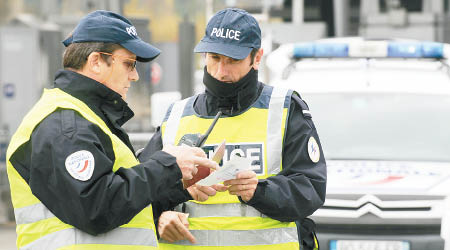 在法國接壤西班牙邊界，法國警員檢查過境駕駛者的證件。