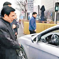 王安順（左）與交警截查一輛違規的單號汽車。