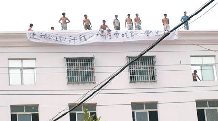多名農民工危站樓頂邊緣。（互聯網圖片）