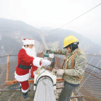 景區高層扮成聖誕老人向建橋工人送禮物。