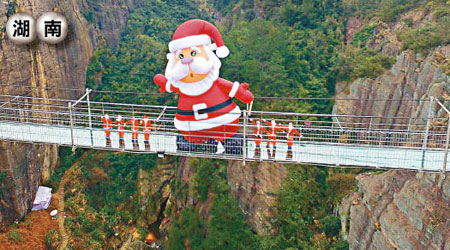 近十米高的聖誕老人在玻璃橋上搖搖欲墜。（中新社圖片）