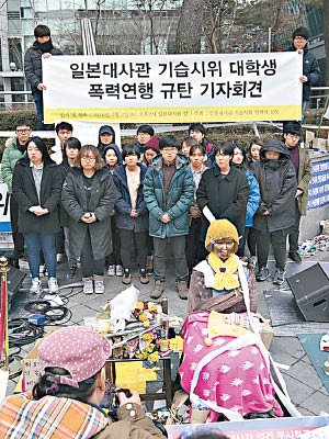 南韓一班年輕人在象徵慰安婦的少女雕像前示威。（互聯網圖片）