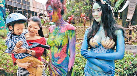 遊客與彩繪女子合照。（互聯網圖片）