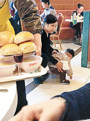 涉事家長抱着小孩，在餐廳當眾大便。（互聯網圖片）