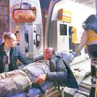 一名男子傷勢嚴重，被救護員抬上車送院。