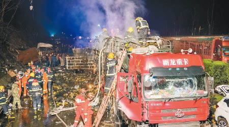 一輛大貨車嚴重損毀，大批消防到場灌救。（中新社圖片）