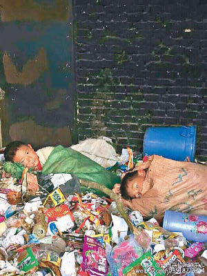 兩名學生躺在垃圾堆上，用麻布袋蓋身。