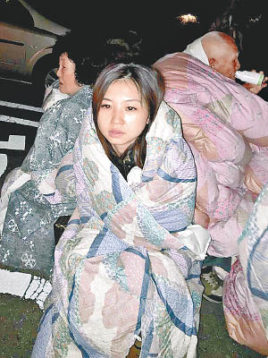 台灣旅客在戶外露宿，以棉被裹身。（中時電子報圖片）
