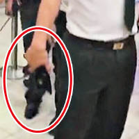 越南邊檢人員手持電槍（紅圈示）威嚇遊客。