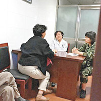 兩名醫院負責人在辦公室接待病人家屬。