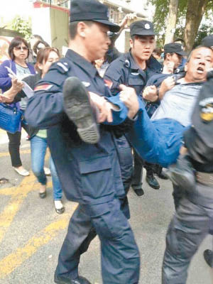 江蘇有警員將示威家長抬走。（互聯網圖片）