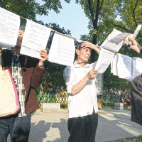 河南洛陽周王城廣場成民間紀念的地點，長者閱讀肯定文革的文章。