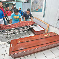 救援人員將遺體放進棺木。
