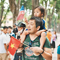 一對越南父女分別手持美國及越南的國旗歡迎奧巴馬。