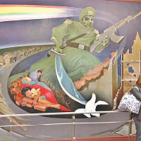 畫中男子戴着防毒面具，手持寶劍及步槍。