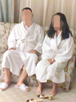 一對男女身穿白色浴袍坐在梳化上，狀甚無奈。