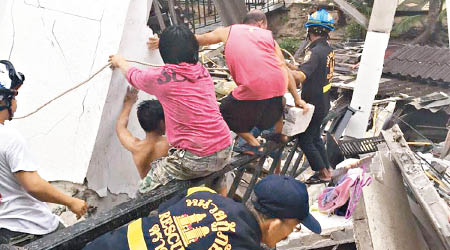 拯救人員在瓦礫上嘗試救出被困的人。（互聯網圖片）