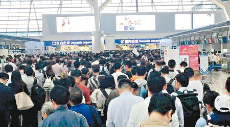 上海浦東機場昨日擴大安檢規模，大批旅客在場等候。（互聯網圖片）