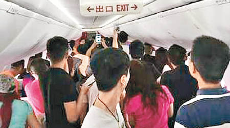 多名乘客圍觀兩名男乘客大鬧機艙的情況。（互聯網圖片）