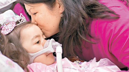 斯諾的母親親吻女兒。（互聯網圖片）