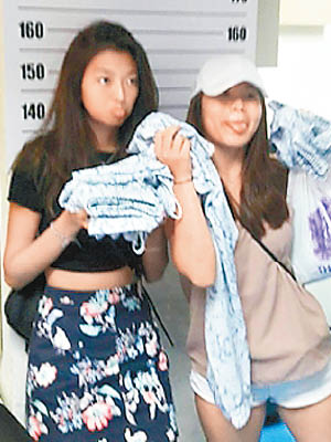 兩名新加坡女子拿起衣物合照。（互聯網圖片）