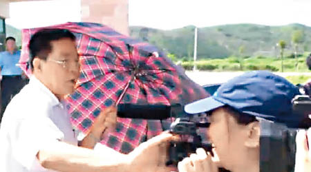 錢漢沛（左）推開女記者的攝錄機鏡頭。