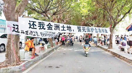 有東莞村民拉起標語，抗議村委會擅自賣地及強拆工廠。（本報東莞傳真）