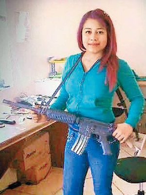 胡安娜手持步槍拍照。（互聯網圖片）