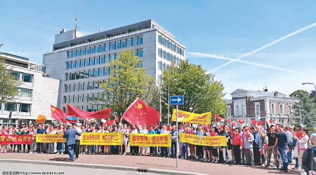 大批華人手持標語到海牙和平宮抗議南海仲裁結果。（互聯網圖片）