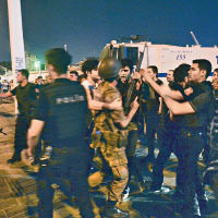 伊斯坦布爾塔克西姆廣場上，有民眾將捉到的叛軍交給警察。