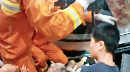 消防員撬開電梯救被夾女童。（互聯網圖片）