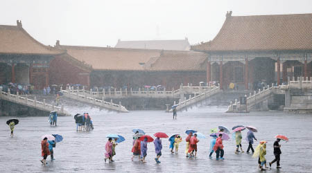 故宮有遊客冒雨遊覽。（中新社圖片）