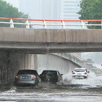 多條馬路嚴重水浸，車輛涉水而行。（中新社圖片）