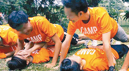 過往曾有參與迎新營的女生躺在地上，男生在其身上做掌上壓。（互聯網圖片）