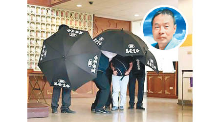 蘇明成（圓圖）的家屬領骨灰時以黑傘遮擋，不發一言。（中時電子報圖片）