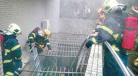 消防員剪破鐵窗灌救。（中時電子報圖片）