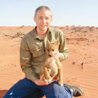 艾倫建議出售狗肉予亞洲國家。圖為他抱着一頭澳洲野犬的幼犬。