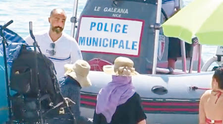 警員驅逐穿長袖衣物的女子。（互聯網圖片）