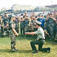 一名軍訓教官單膝跪地向女學生示愛。