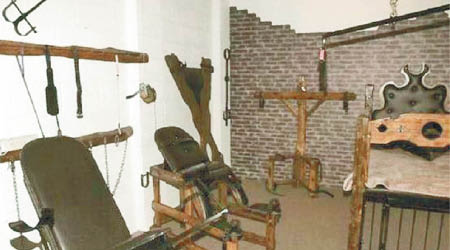 地下囚室內放滿吊鏈、拷問椅、鐵籠等拷問工具。（互聯網圖片）